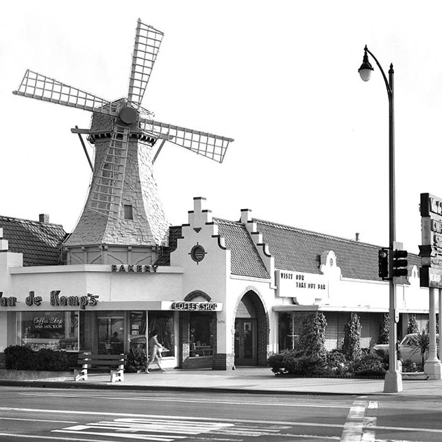 Black-and-white photo of a large Van de Kamp bakery store featuring a Dutch windmill