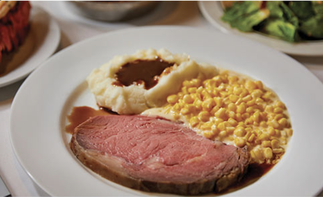 Lawry's The Prime rib with sides of mashed potatoes and creamed corn