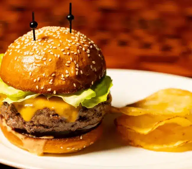 8 oz hand-formed Angus chuck and Prime Rib cheeseburger with American cheese on a toasted sesame bun at Lawry's Beverly Hills
